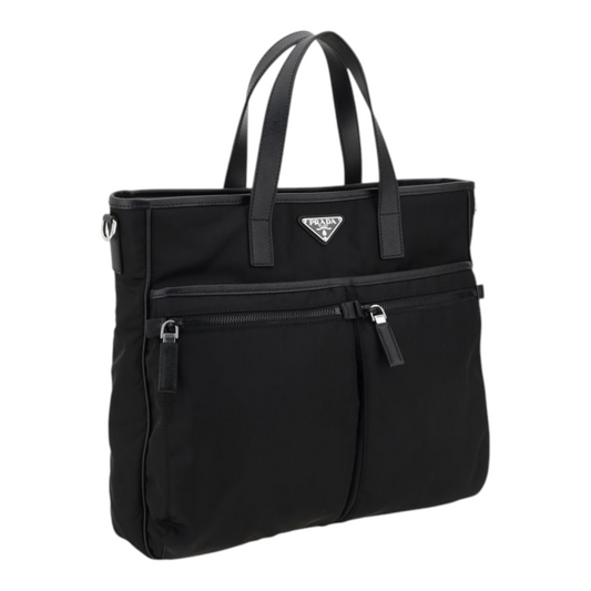 Bolso tote Prada Re-Nylon negro de XT & Co con asas de piel, bolsillos frontales con cremallera y logo triangular.