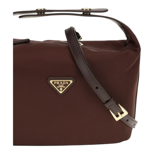 Bolso mini Chérie de XT & Co en Re-Nylon color burdeos con detalles de piel y logo triangular esmaltado