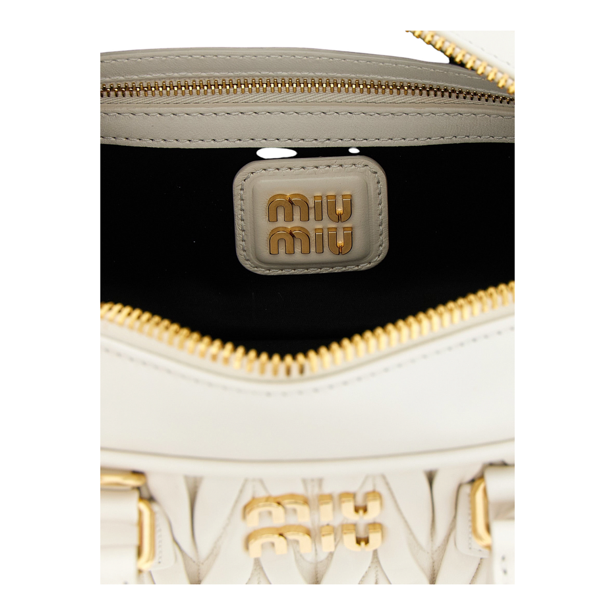Detalle interior del bolso Arcadie de XT & Co en piel nappa matelassé blanca con logo metálico dorado
