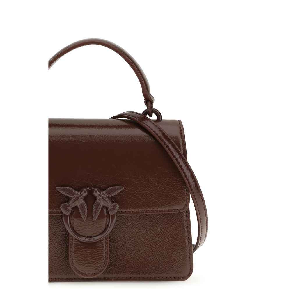 PINKO burgundy goatskin handbag with top handle and shoulder strap, front view.