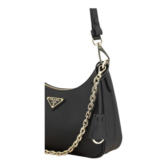Bolso de hombro Prada Lux en piel Saffiano negra con correa de cadena dorada y placa triangular de XT & Co
