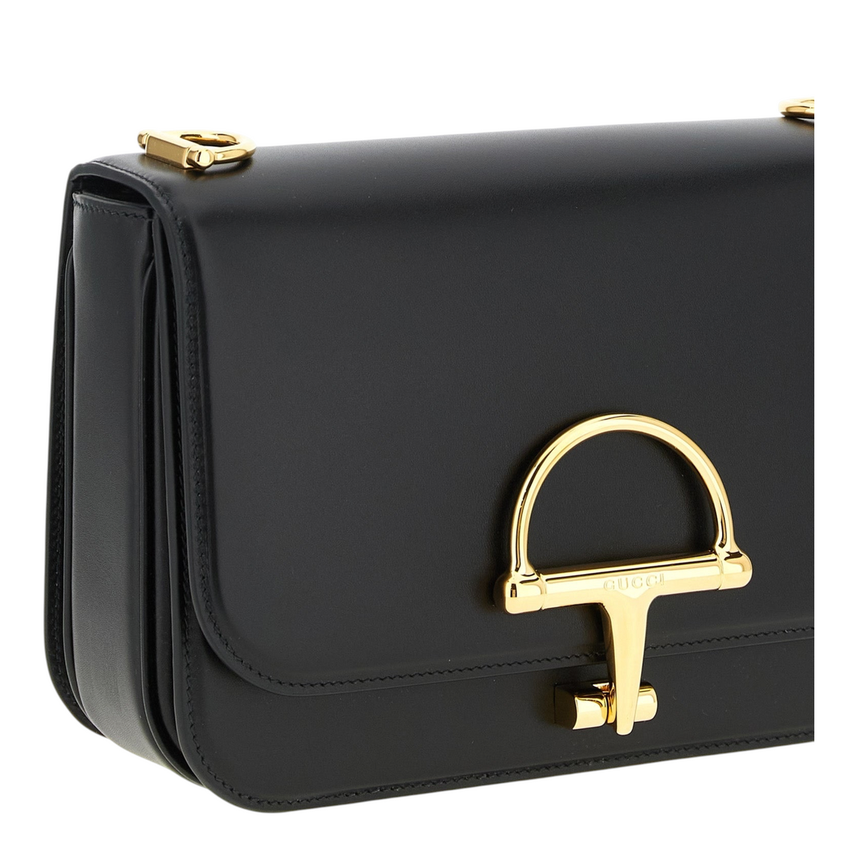 Bolso bandolera Siena de XT & Co en piel de becerro negra con detalle de medio bocado metálico dorado en la solapa.