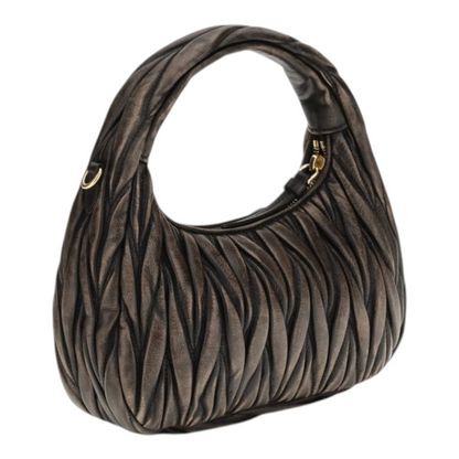 Bolso hobo Wander de XT & Co en piel nappa marrón con diseño acolchado matelassé y herrajes dorados.