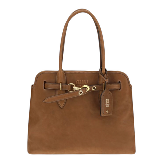 A brown leather handbag with double top handles, a front strap detail, and gold-tone hardware, shown against a plain white background.