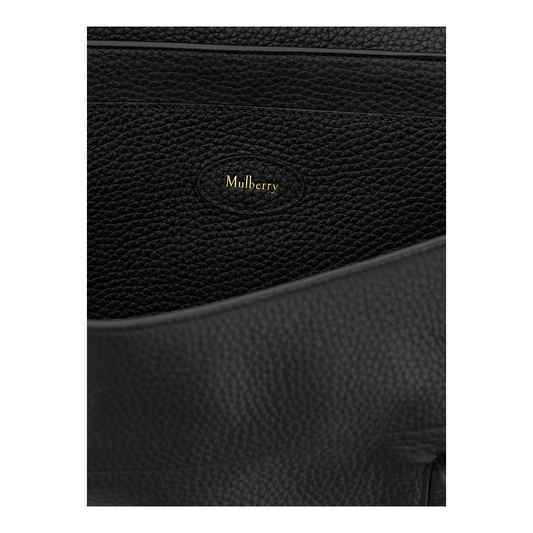 Detalle del logo Mulberry en relieve dorado sobre piel de becerro granulada negra del bolso XT & Co