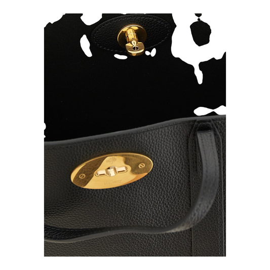 Detalle del cierre Postman's Lock dorado en el bolso tote Bayswater de piel negra granulada de XT & Co
