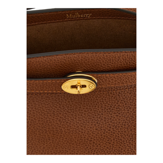 Detalle del cierre Postman's Lock dorado en el bolso tipo cubo Mulberry Islington de piel granulada marrón de XT & Co