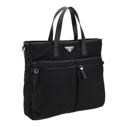 Bolso tote Prada Re-Nylon negro de XT & Co con asas de piel, bolsillos frontales con cremallera y logo triangular.