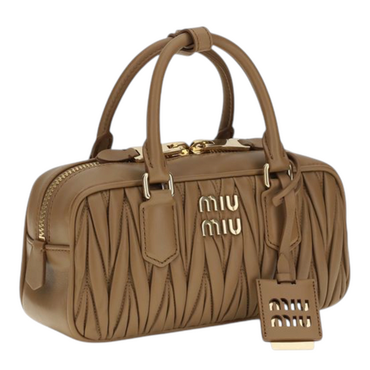 Bolso de hombro Arcadie de XT & Co en piel beige con textura matelassé, asas tubulares y placa con logo metálico.