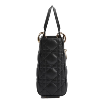 Bolso Lady Dior XT & Co de piel de cordero negra con patrón acolchado cannage y asas rígidas, vista lateral.