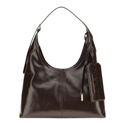 Bolso de hombro XT & Co The Belted Sack en piel marrón brillante con etiqueta de equipaje extragrande y correa ajustable