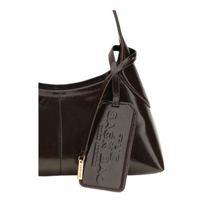 Bolso saco pequeño XT & Co de piel marrón brillante con etiqueta de equipaje y correa ajustable