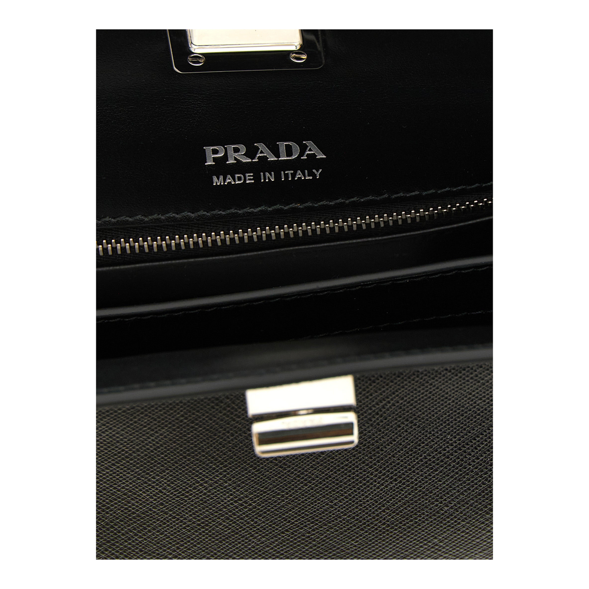 Interior del bolso XT & Co Prada Midi en piel Saffiano negra con logo plateado y cierre a presión