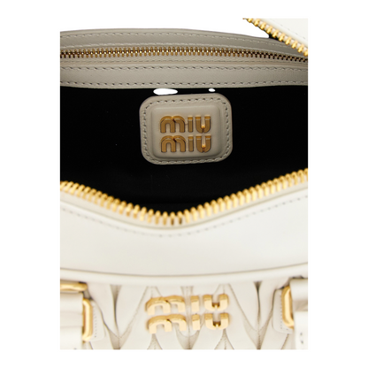 Detalle interior del bolso Arcadie de XT & Co en piel nappa matelassé blanca con logo metálico dorado